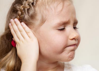Jeune fille ayant des douleurs à l'oreille à cause des oreillons