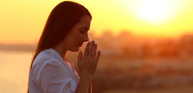 une femme est entrain de faire une prière.