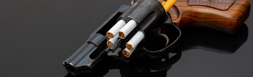 Revolver noir et marron chargé avec des cigarettes