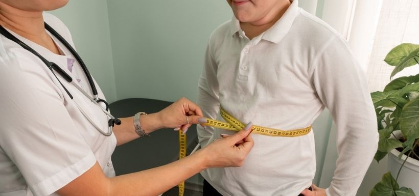 Doctor measuring the waist circumference of a small child