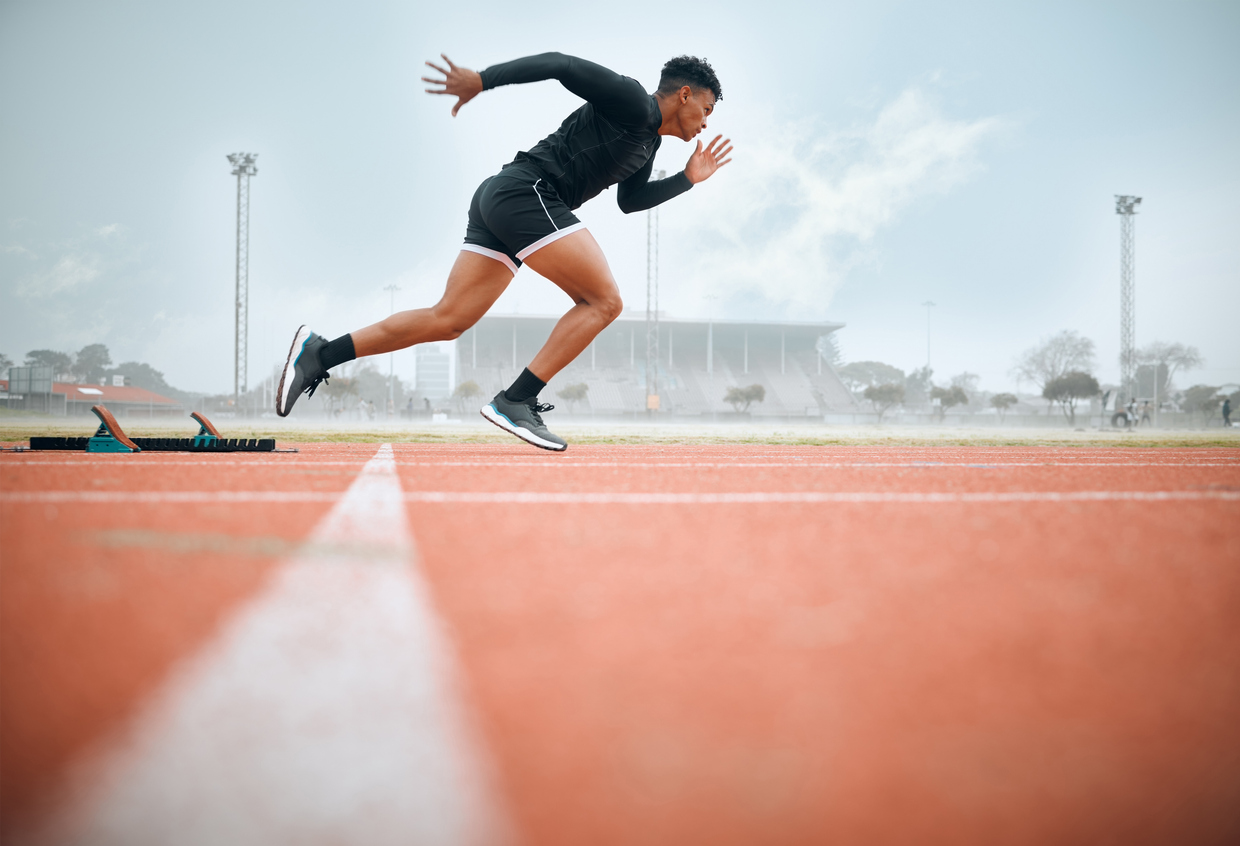 Man, athlete and ready for race on track with practice, training or exercise for competition. Black person, runner and fast with dedication, determination and passion on face with speed for sport