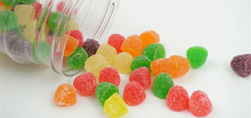 Gummies fruitées s’échappant d’un pot transparent